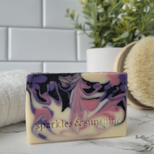 Picture of white soap with black, pink, and purple swirls