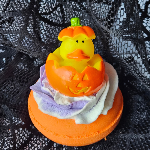 Picture of Halloween-costumed rubber duck sitting on a bath bomb doughnut.